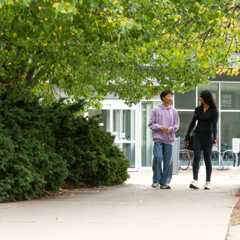 Two students walk outside.