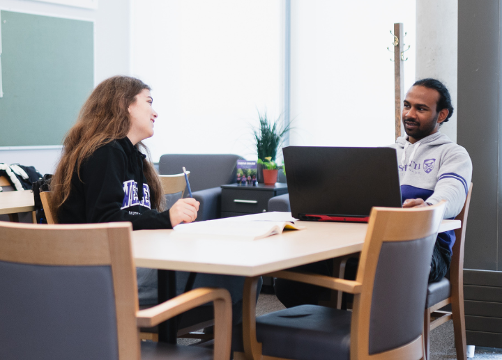 Two students study in a modern library space.