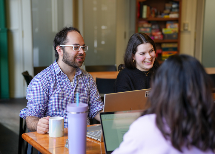 Graduate students gather at a restaurant to have a conversation.