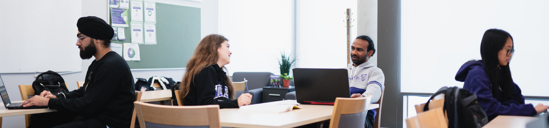 Several students working on laptops in an academic setting.